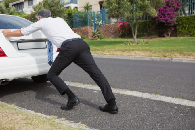 Man pushing broken down car: SBDPro Automotive Blog