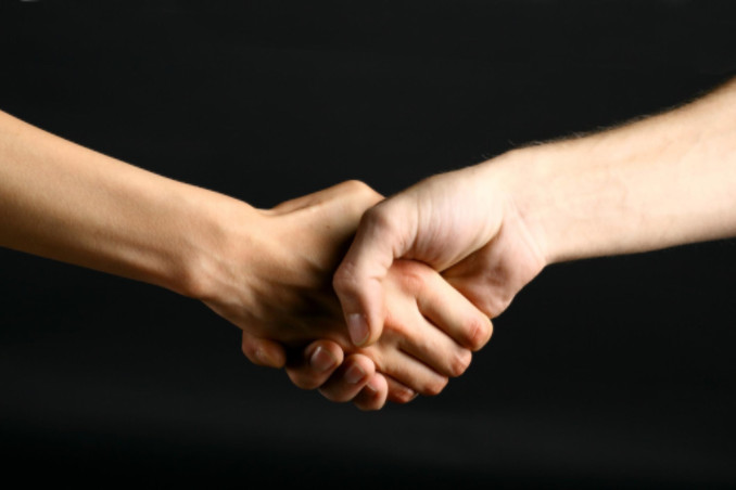 Two people shaking hands on black backdrop: Max Auto Pro Auto Advice Blog